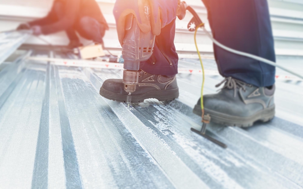 Worker Drilling Into A Metal Roof